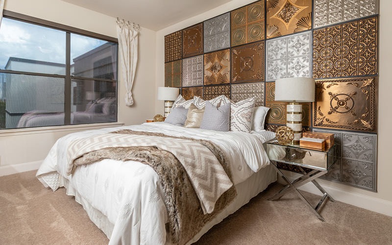 spacious, carpeted bedroom with large windows